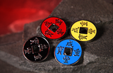 Four round Chinese-style coins with square holes, featuring red, yellow, black, and blue enamel faces with gold Chinese characters, for magic tricks arranged on a dark textured stone surface with a glowing red cave background.