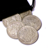 Five silver dollars with detailed designs on a white background