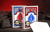Double Blank Bicycle Playing Cards on dark stones with a glowing red cave background