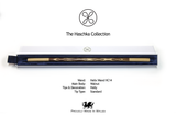 A decorative wand from The Haschka Collection, displayed horizontally inside its white and navy blue presentation box. The wand features a light wood body with dark brown twisted details and a silver-toned tip.