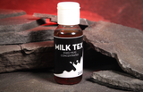 A 20ml bottle of Milk Tex (Fake Milk) Concentrated liquid, featuring a black label with white text and a white cap, set against a dark slate background with a glowing red cave backdrop.