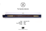 Wooden wand with decorative elements in a box, branded 'The Haschka Collection', on a white background.