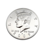 A silver-colored half dollar coin shell with an engraved face, designed for coin magic, showing the date 2009.
